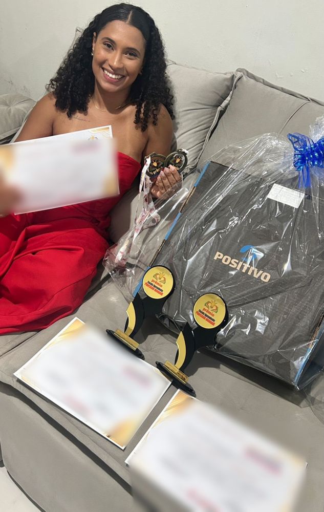 Thauany com certificados, medalhas e troféus do Prêmio Escola Aprendente Professor Inovador
