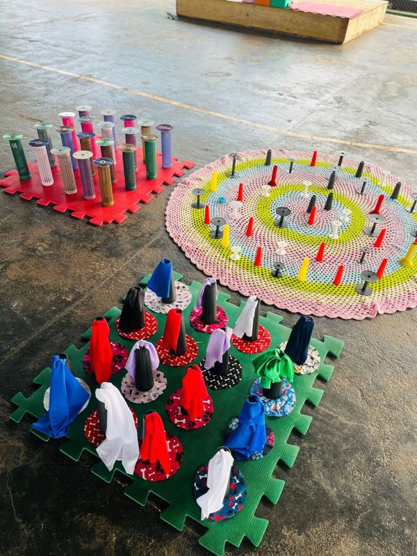 Espaço com carretéis, cones e tecidos sobre tapetes
